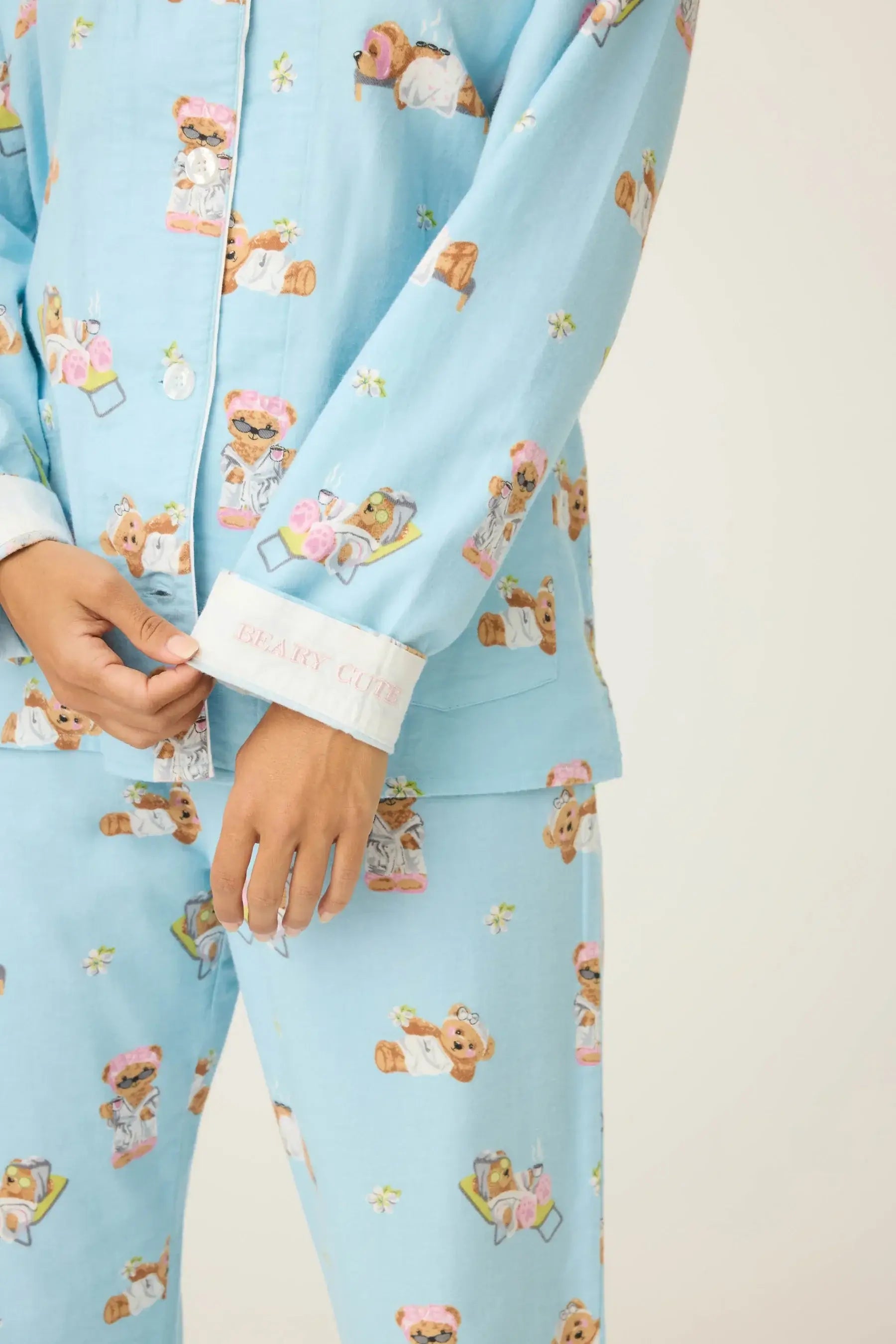 Woman wearing the Beary Cute Bear Print Flannel PJ Set featuring cute bear illustrations on a light blue background.