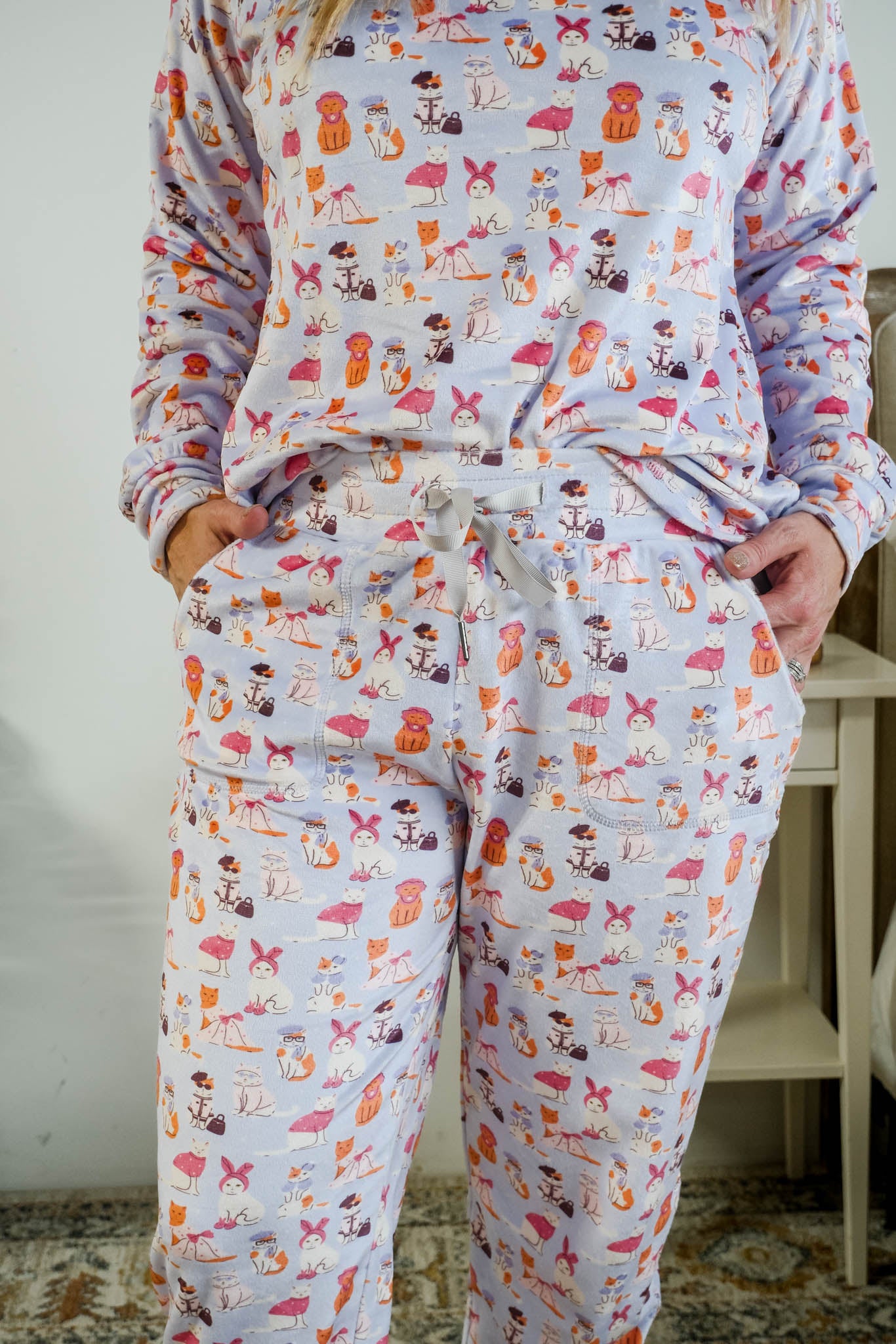 Showing the drawstring detail and pockets on the Miranda Nic women's purple velour long sleeve top and jogger pants set featuring Catwalk Kitties cat print - Cloud Nine Pajamas