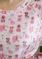 Close up of person wearing Miranda Nic women's pink velour long sleeve top and jogger pants loungewear set featuring Chic Puppies dog print showing print and texture