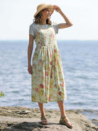April Cornell Milene Cotton Pinafore Dress – Sage Green Midi with Hand-Crochet Neckline model show on a rocky beach