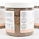 Coffee Bean Sugar Scrub jar with labels highlighting key ingredients and benefits.