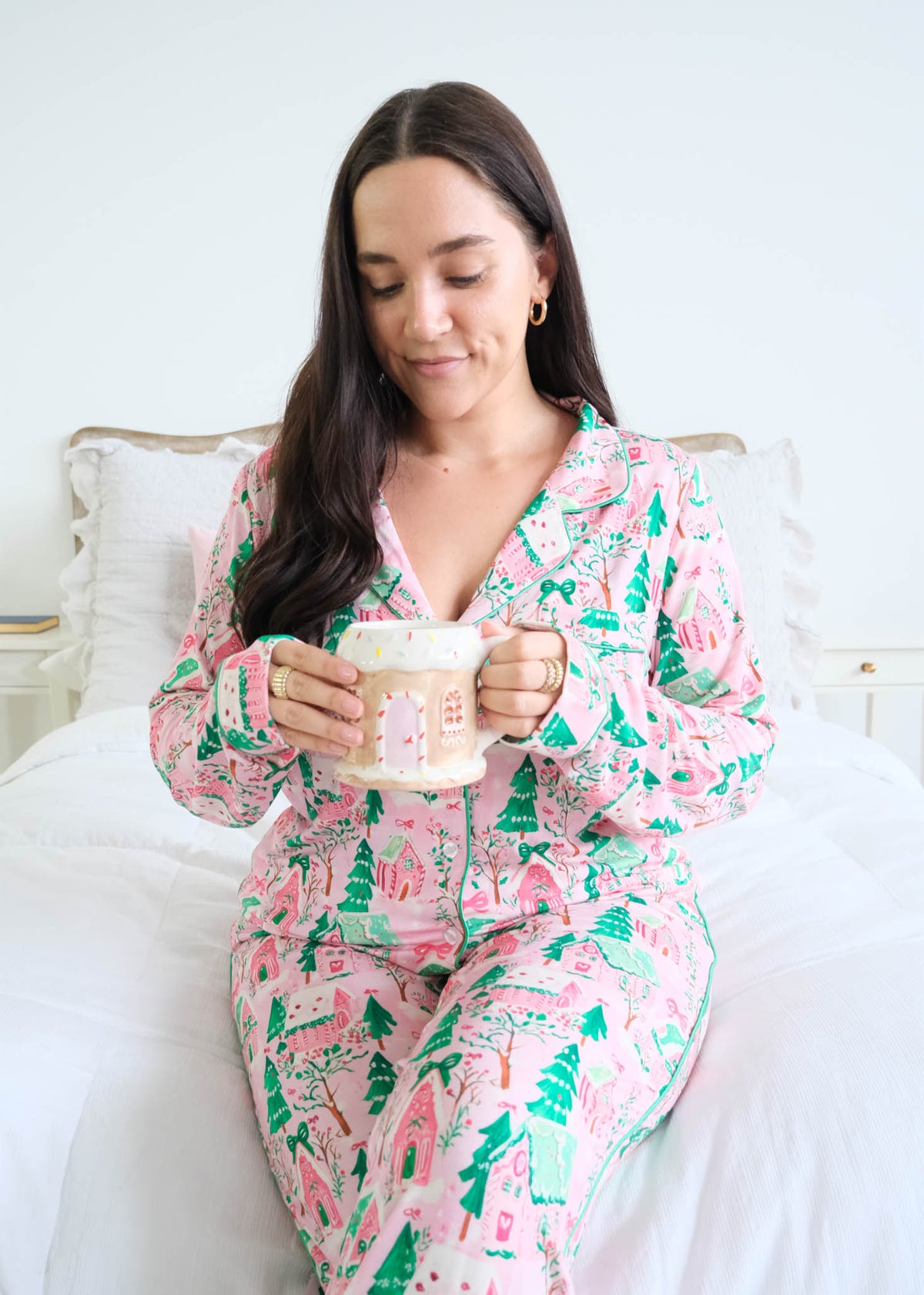 Georgia Rylan Sugar Plum Dreams gingerbread house print close-up sitting model on bed — Cloud Nine Pajamas Edmonton
