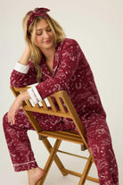 Woman wearing a burgundy pajama set with a white background western horses print pj salvage