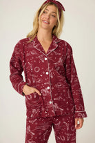Woman wearing a burgundy pajama set with a white background western horses print pj salvage