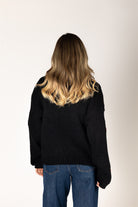 Lyla & Luxe Lexi Hand Knit Cherry Cardigan Black Red model back view — Cloud Nine Pajamas