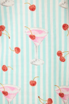 Ma Cherie Cherry Print featuring cocktails and cherries on a blue striped background.