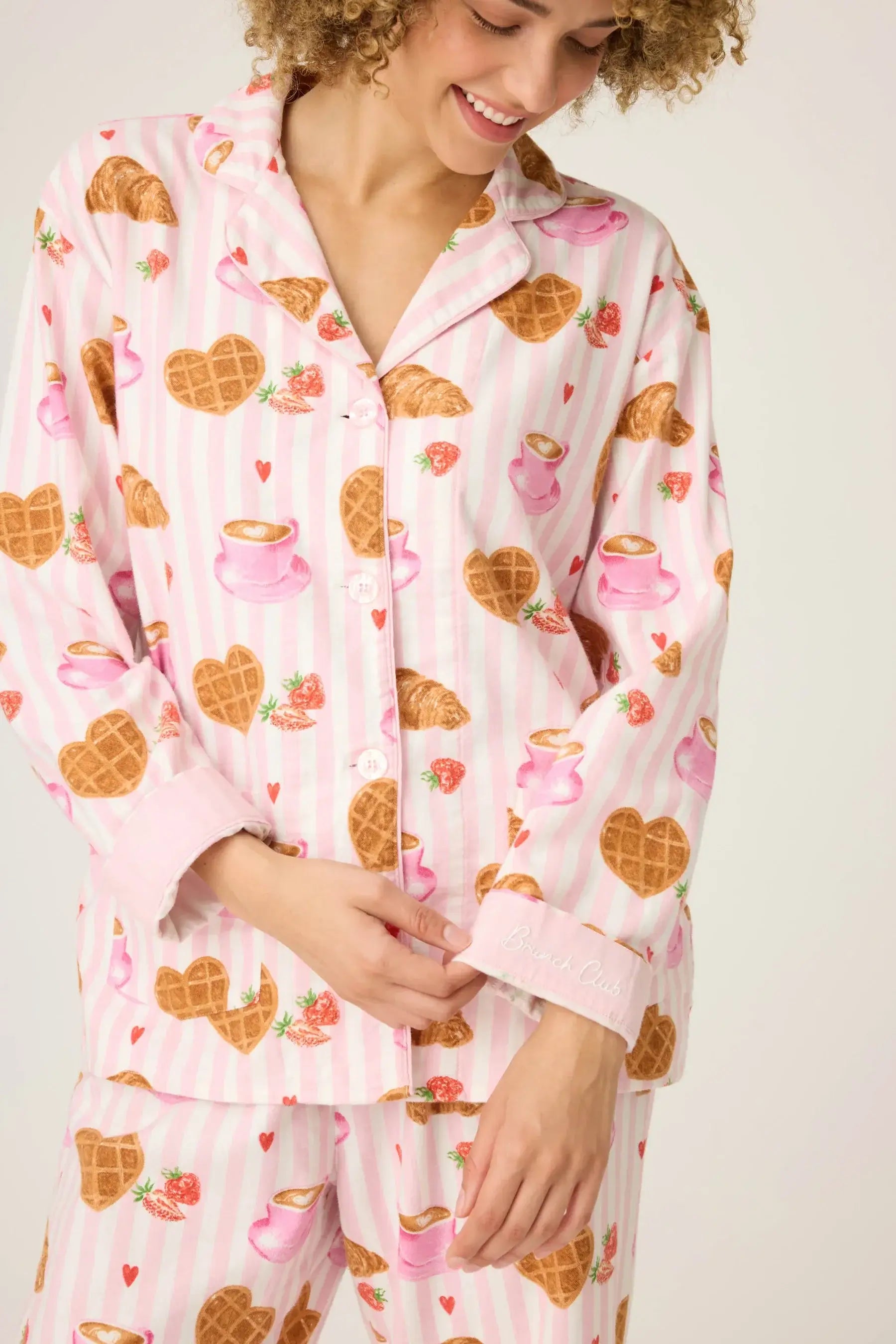 Woman smiling in Brunch Club Breakfast Print Flannel PJ Set featuring waffle and tea cup patterns.