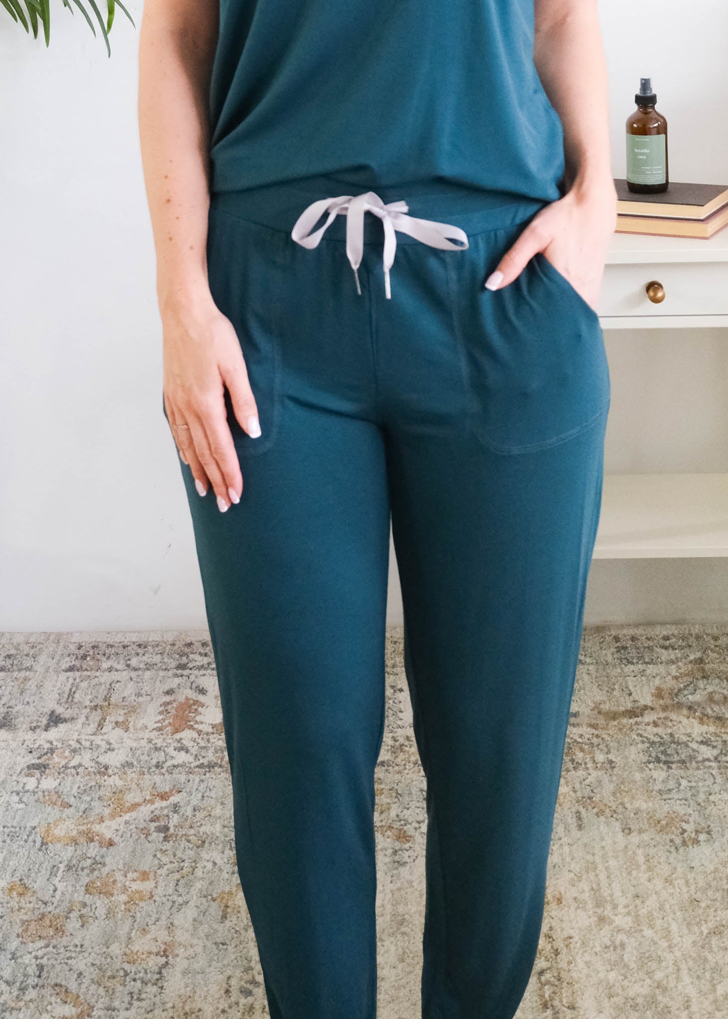 A person wearing dark teal pants with a grey ribbon drawstring and side pockets, the person is wearing the Pj Tee Jogger Midnight Teal Bamboo Pj Set. Cloud Nine Pajamas Edmonton