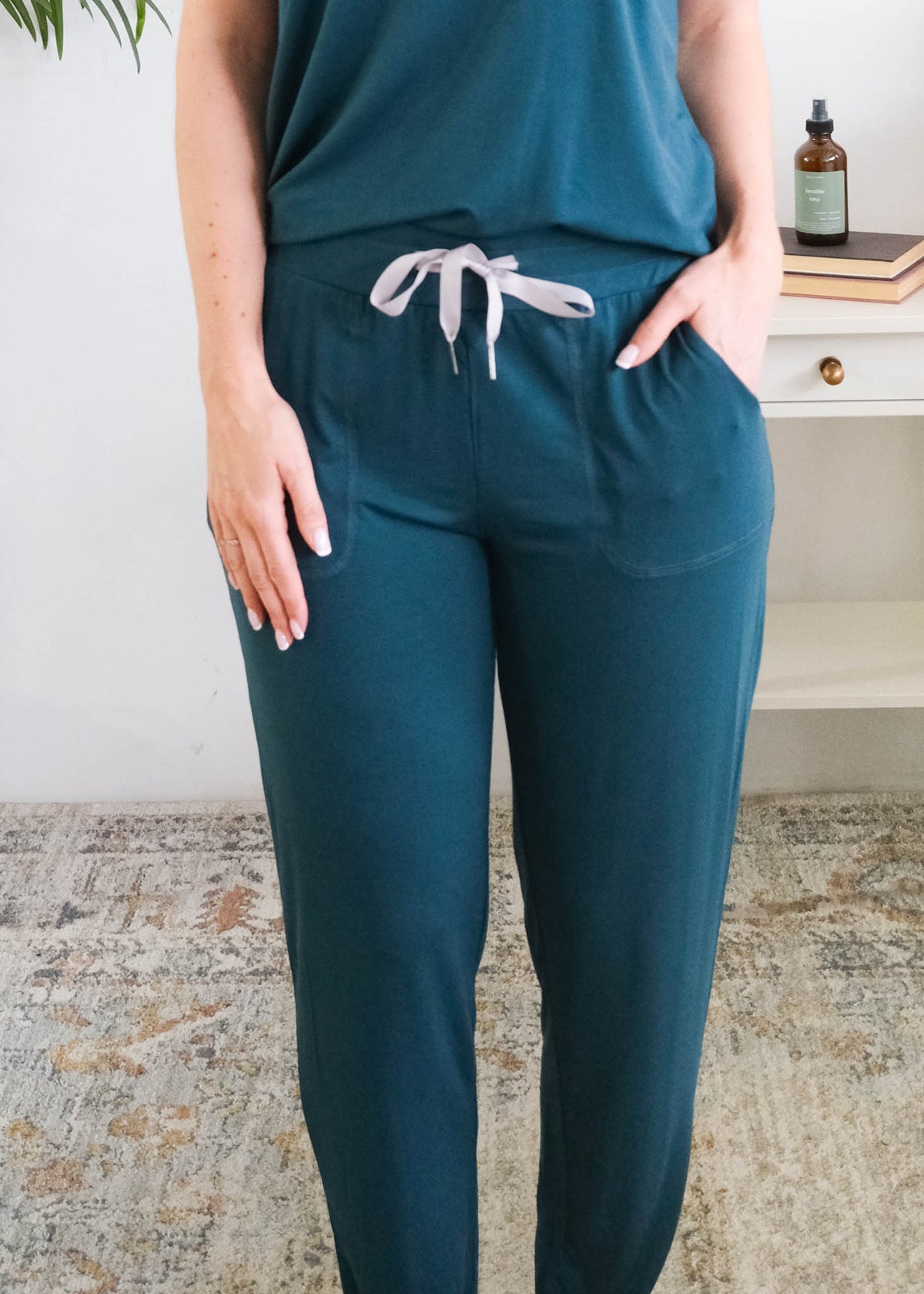 A person wearing dark teal pants with a grey ribbon drawstring and side pockets, the person is wearing the Pj Tee Jogger Midnight Teal Bamboo Pj Set. Cloud Nine Pajamas Edmonton