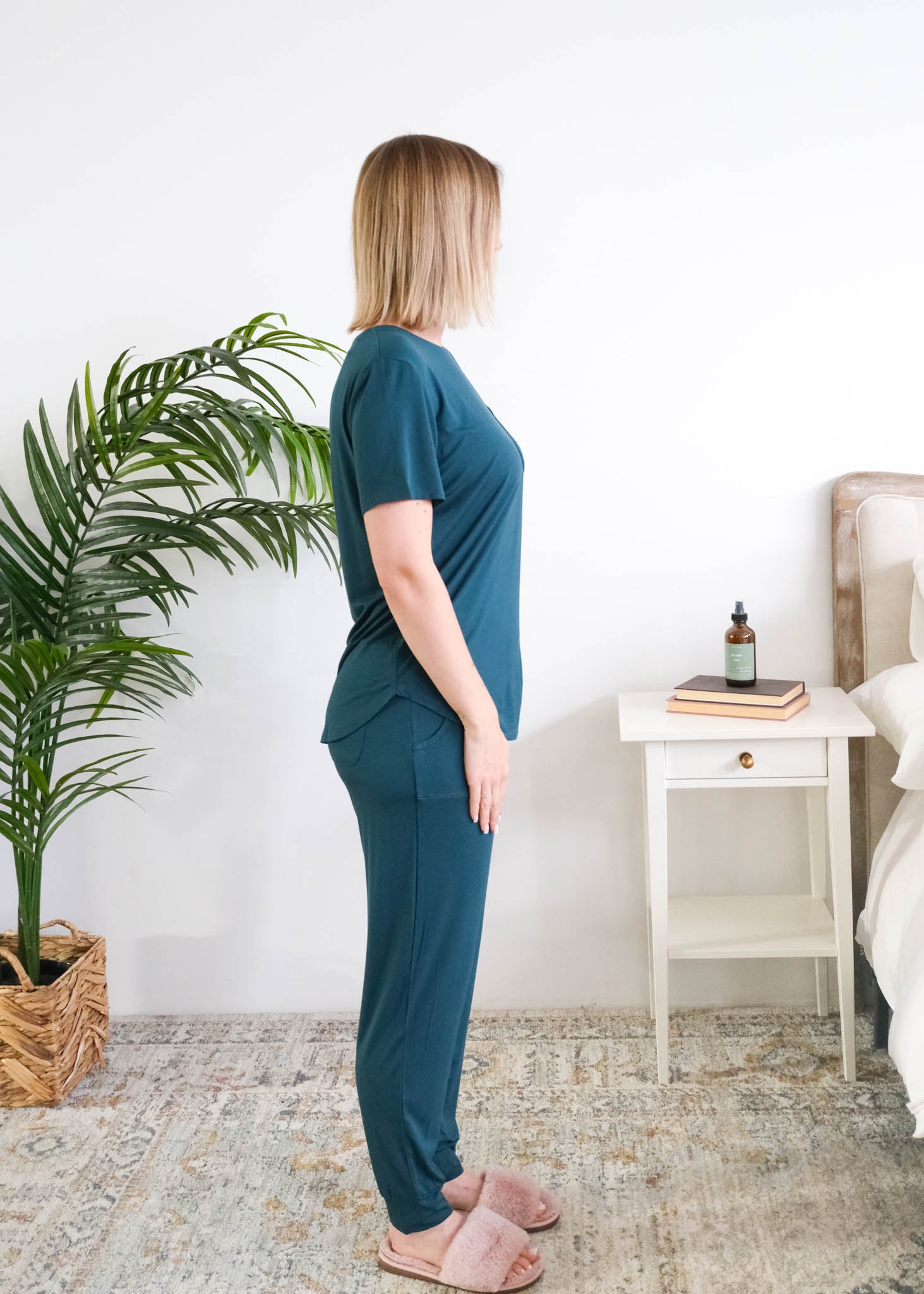 Side view of a woman standing wearing the Tee/Jogger PJ Set in Midnight Teal, showing the fit through the torso and jogger leg. Cloud Nine Pajamas Edmonton