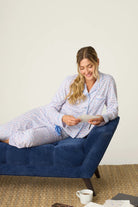 Woman lounging on a blue couch wearing the Whimsy Walk On The Wild Side PJ Set from PJ Salvage, enjoying her time.