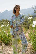 Model wearing Whimsy Postcards From Paris PJ Set in a floral outdoor setting with mountains in the background.