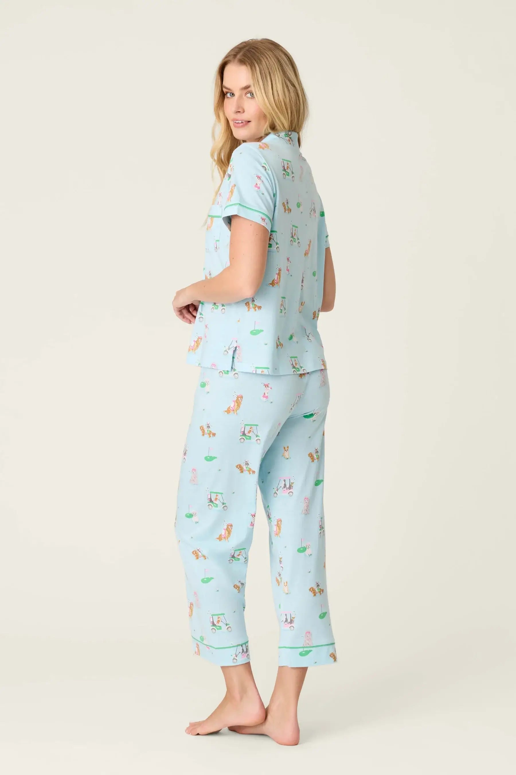 PJ SALVAGE Whimsy Cropped PJ Set in Light Blue Putter Pup print showing dogs golfing. Model stands wearing the set against a light background in a view of the back