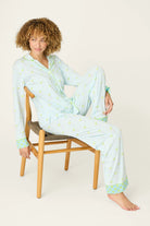 Playful Prints Cotton-Modal Long Sleeve Pajama Set by PJ Salvage model wearing blue and green pajamas sitting on a chair
