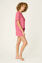 PJ SALVAGE Graphic Print Softee Tee & Short Lounge Set in "Time to Wine Down" rose pink. Model stands against a light background in a side profile shot