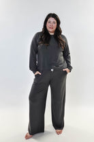 Model wearing the Long Sleeve Raw Edge Straight Pant Lounge Set in gray, featuring a relaxed fit and pockets.