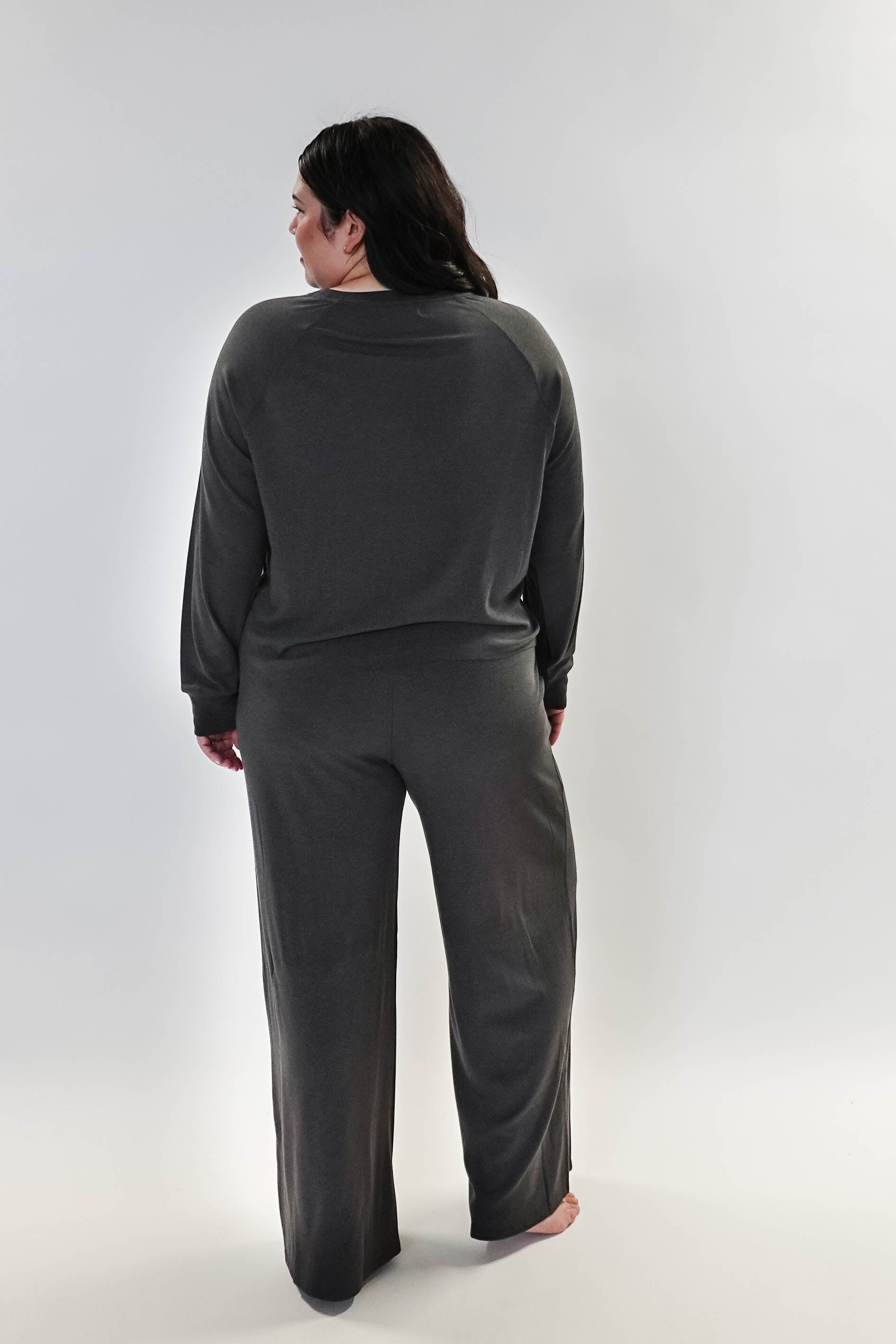 Woman wearing Long Sleeve Raw Edge Straight Pant Lounge Set, viewed from behind, showcasing the relaxed fit and stylish design.