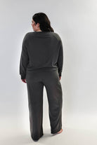 Woman wearing Long Sleeve Raw Edge Straight Pant Lounge Set, viewed from behind, showcasing the relaxed fit and stylish design.