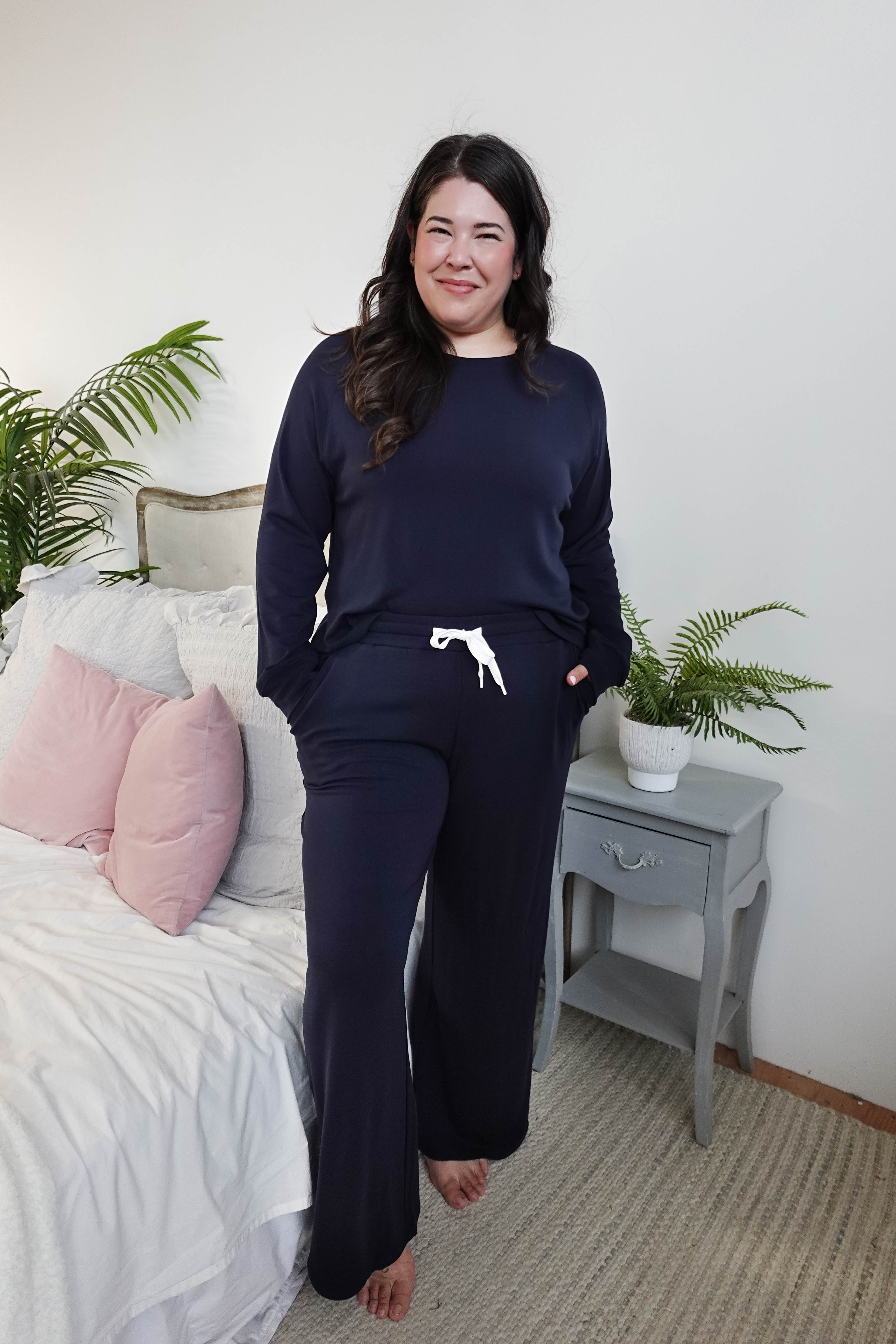Model wearing Long Sleeve Raw Edge Straight Pant Lounge Set in navy color, posing in a cozy bedroom setting.