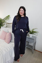 Model wearing Long Sleeve Raw Edge Straight Pant Lounge Set in navy color, posing in a cozy bedroom setting.