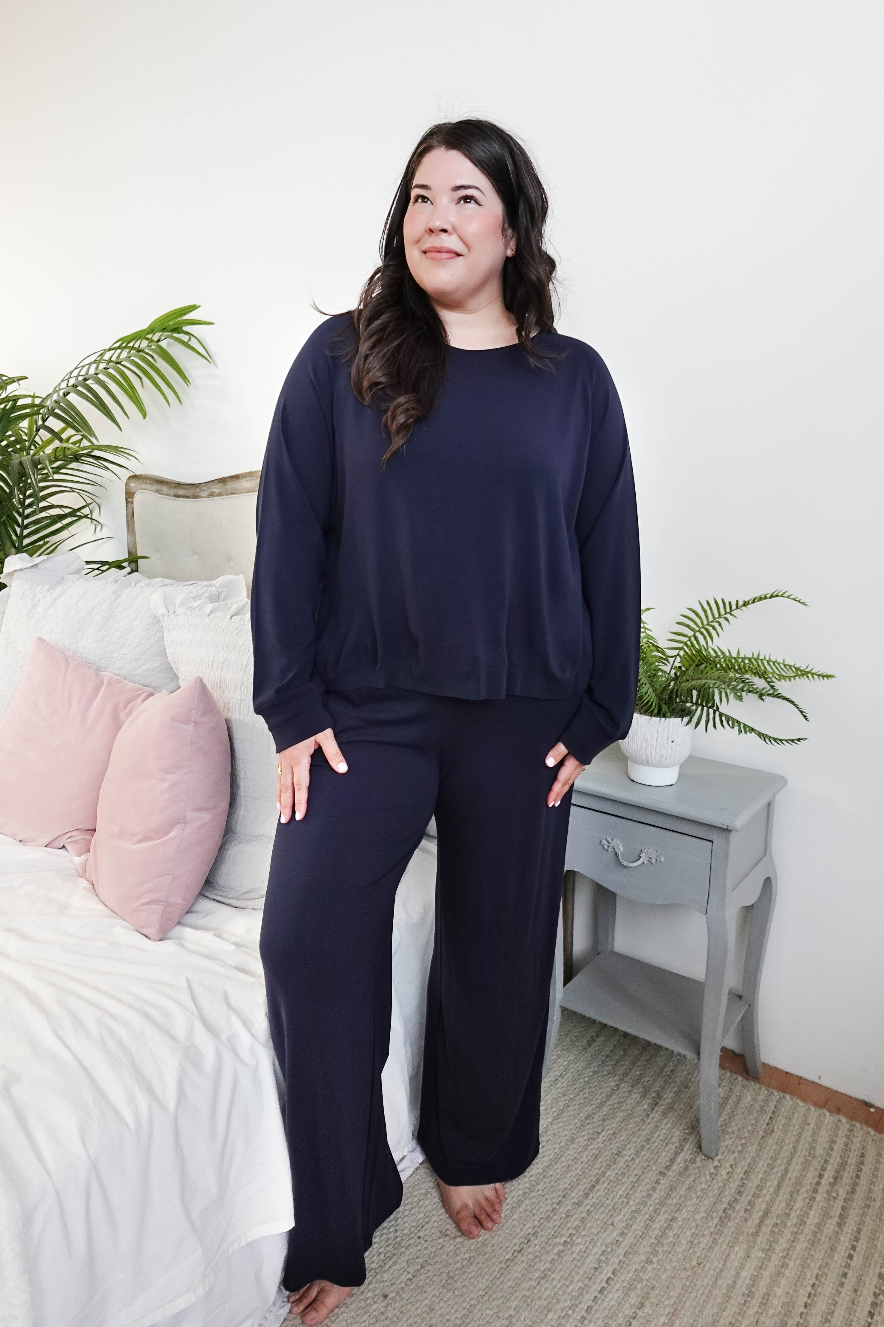 Model wearing Long Sleeve Raw Edge Straight Pant Lounge Set in navy color, styled in a cozy bedroom setting.