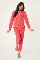Woman wearing Ski Jammie Classics Brushed Thermal PJ Set, featuring playful winter prints in red and pink.