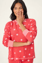  Woman wearing Ski Jammie Classics Brushed Thermal PJ Set, featuring playful winter prints in red and pink snowflake wishes