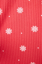  Woman wearing Ski Jammie Classics Brushed Thermal PJ Set, featuring playful winter prints in red and pink snowflake wishes