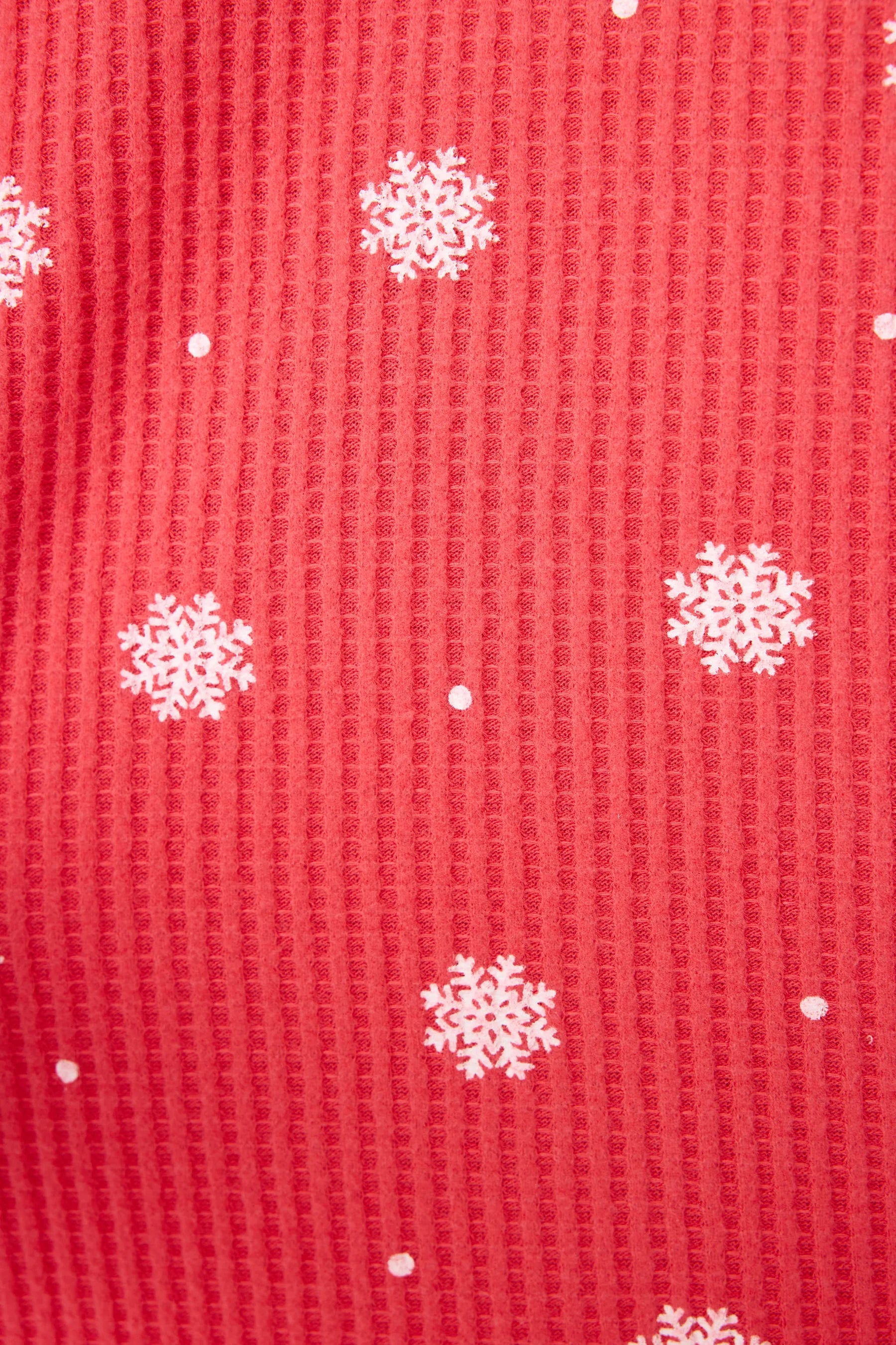  Woman wearing Ski Jammie Classics Brushed Thermal PJ Set, featuring playful winter prints in red and pink snowflake wishes