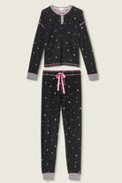  Woman wearing Ski Jammie Classics Brushed Thermal PJ Set, featuring playful winter prints in black starlight starbright star print