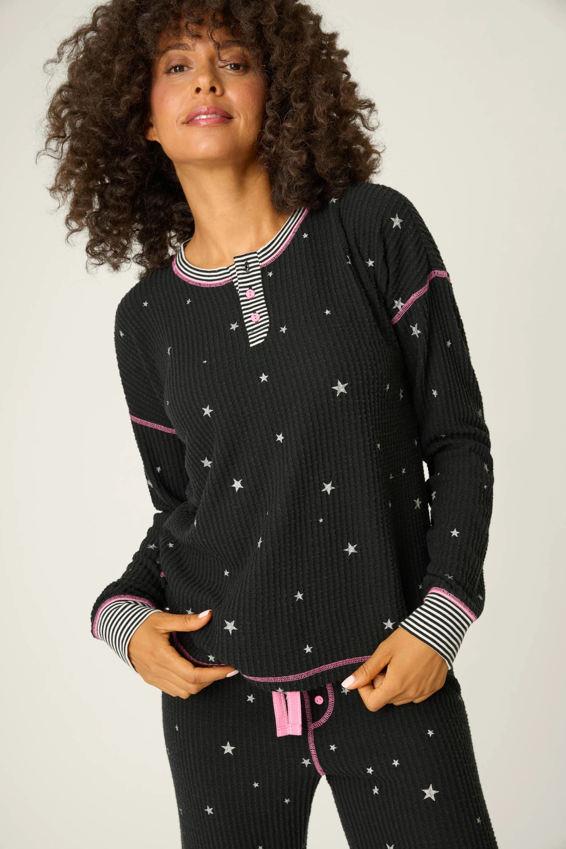  Woman wearing Ski Jammie Classics Brushed Thermal PJ Set, featuring playful winter prints in black starlight starbright star print