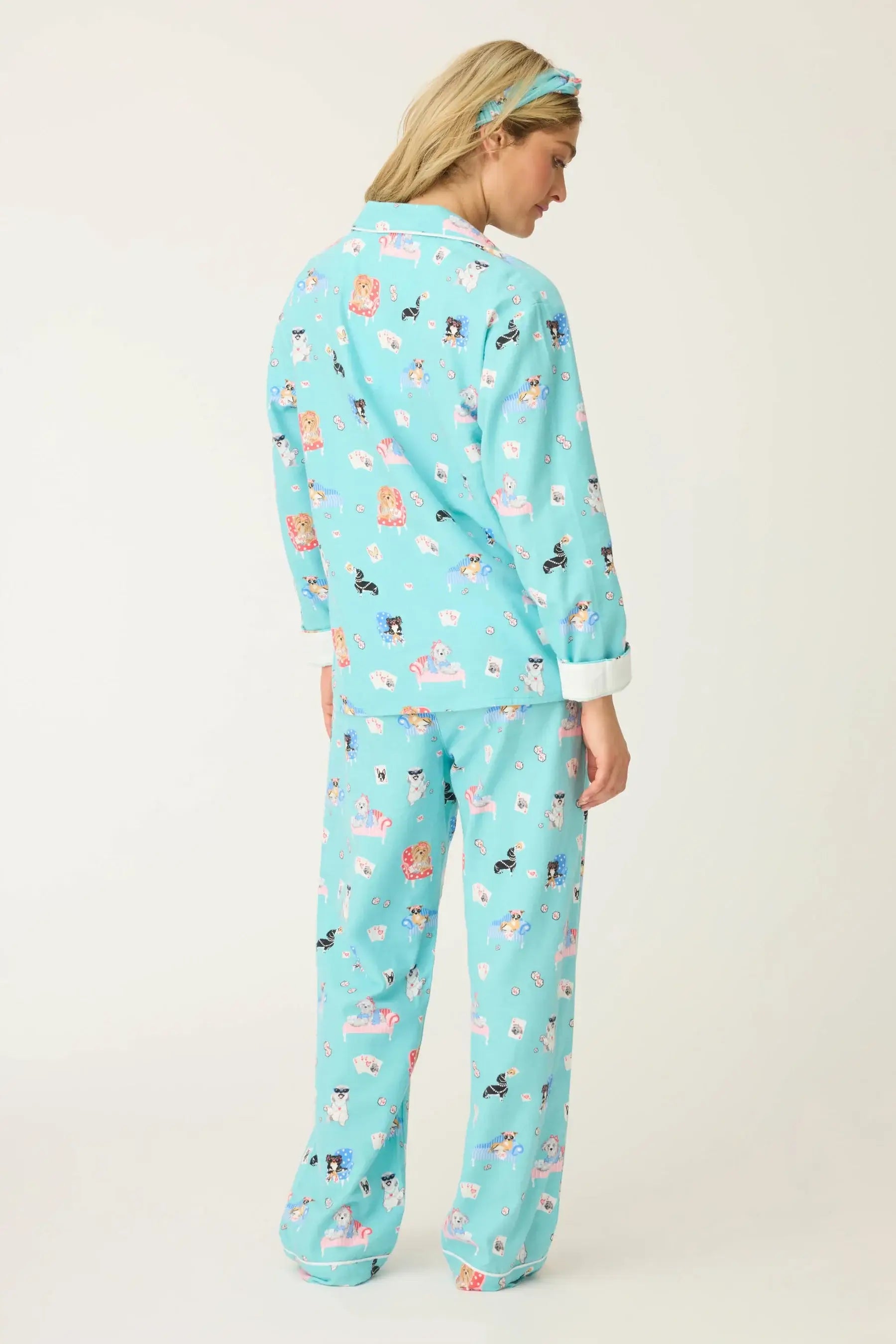 Woman wearing This Is How I Roll Dog Print Flannel PJ Set from PJ Salvage, showcasing fun dog designs in turquoise.