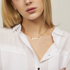 Zodiac Script Necklace in 14K Plated Gold featuring the Pisces astrological sign on a bright yellow display card.