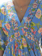 April Cornell Lillian Rayon Dress – Blue Floral Maxi with Pockets, featuring vibrant floral patterns and a flattering neckline.