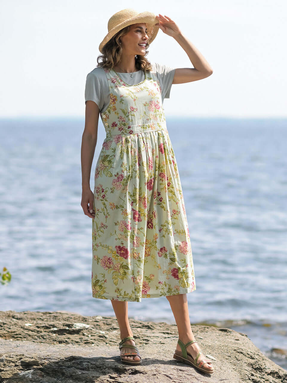 April Cornell Milene Cotton Pinafore Midi Dress Sage Green with Hand-Crochet Neckline model show on a rocky beach