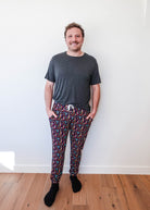 Man wearing Arcade After Dark Unisex Bamboo Jogger with graphic design, paired with a gray t-shirt, and socks.