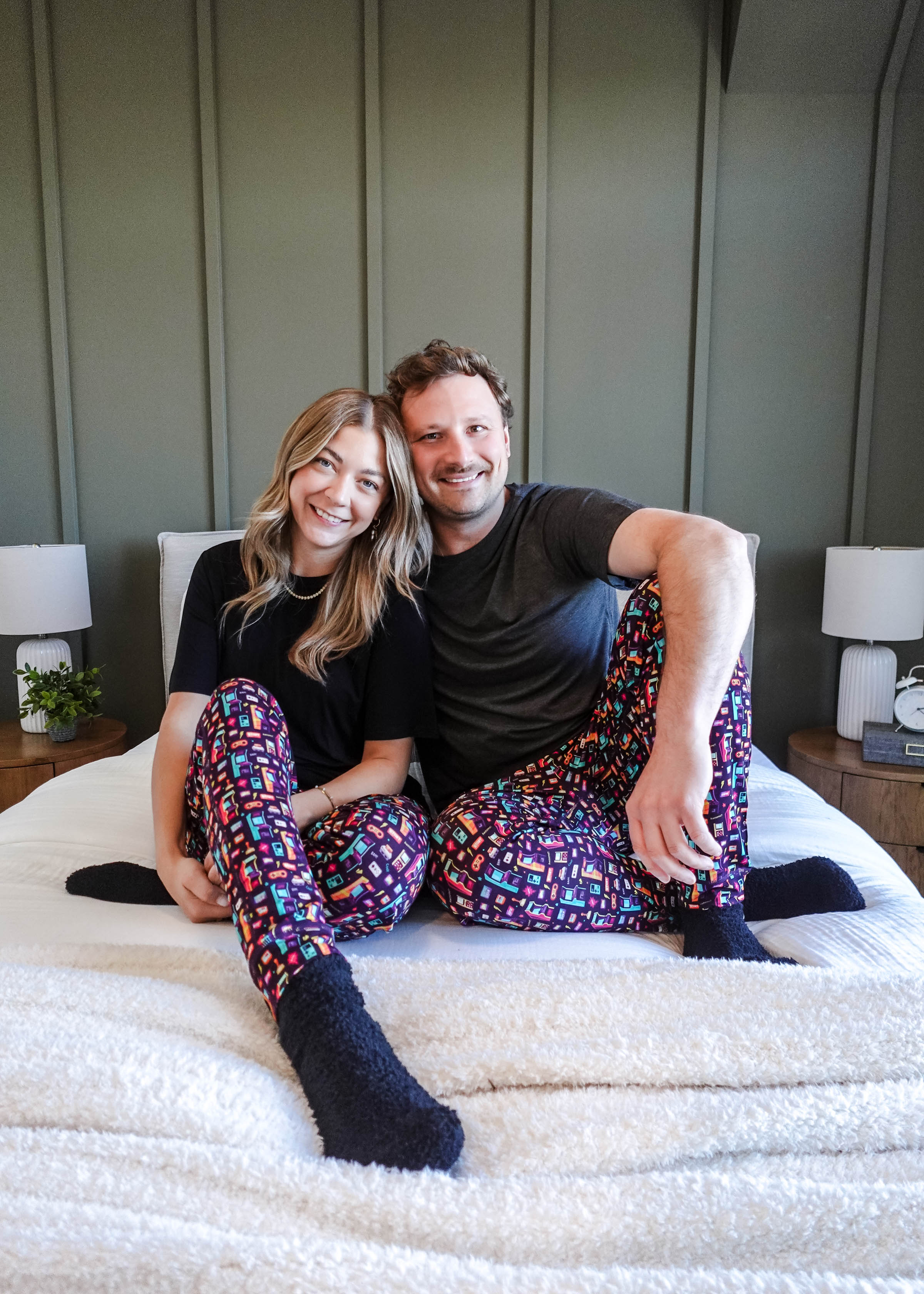 Couple wearing Arcade After Dark Unisex Bamboo Jogger on a bed, showcasing a fun and cozy loungewear style.