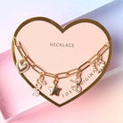 Bella Charm Necklace in 14K Gold featuring heart, star, bow, love script, and pearl charms on a gold chain.