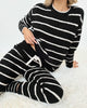 Model wearing the Splendid Cloud-Soft Fuzzy Sweater Pajama Set with black and white stripes, lounging comfortably.