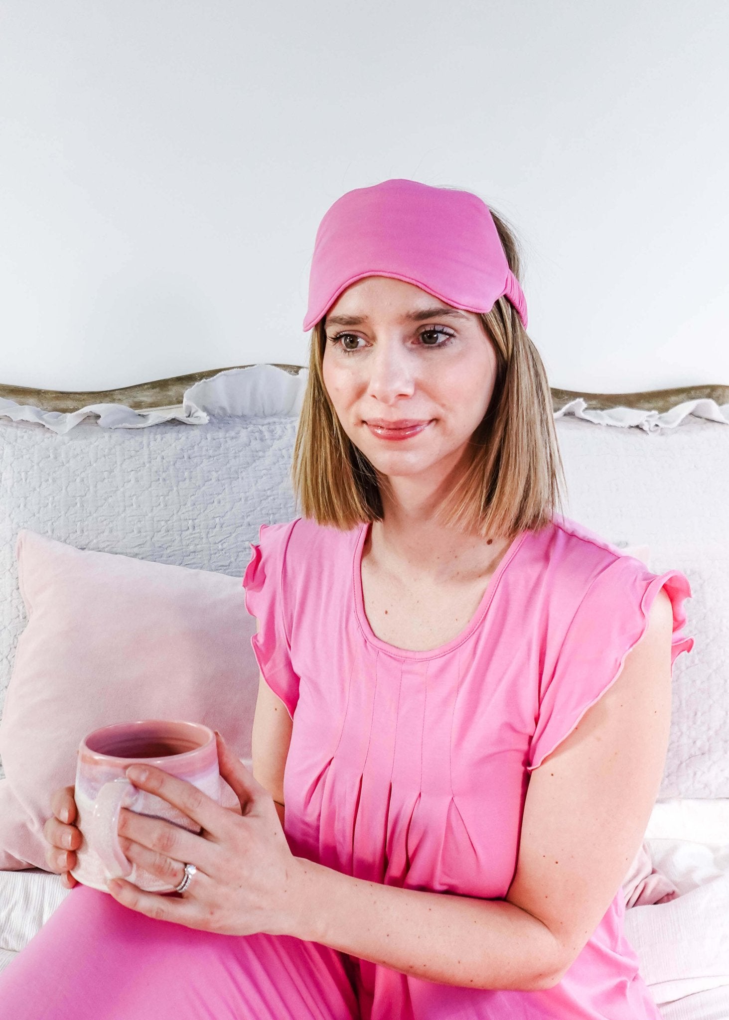 Woman wearing Bubblegum Pink Flutter Top and holding a cup, styled with a matching pink sleep mask.