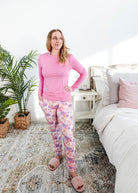 Woman wearing Dream In Blooms Long Sleeve Top & Jogger Bamboo Lounge Set in a cozy bedroom setting.