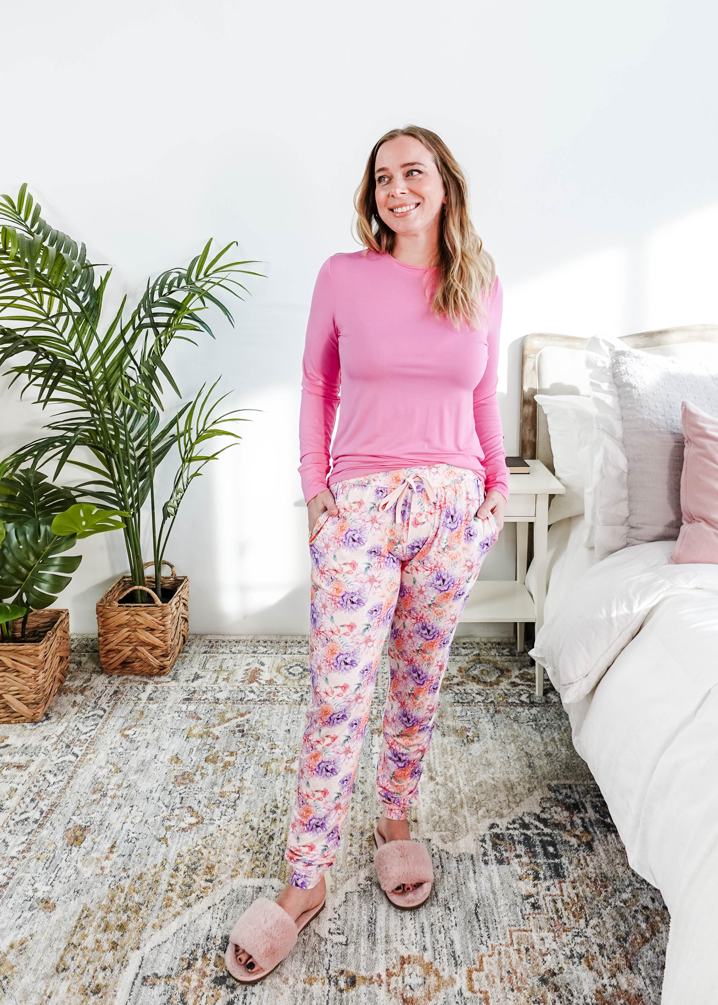 Model wearing the Dream In Blooms Long Sleeve Top & Jogger Bamboo Lounge Set in a cozy bedroom with greenery.