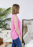 Woman wearing a Bubblegum Pink Essential Bamboo Tank Top, showcasing its comfort and breathable design in a stylish setting.