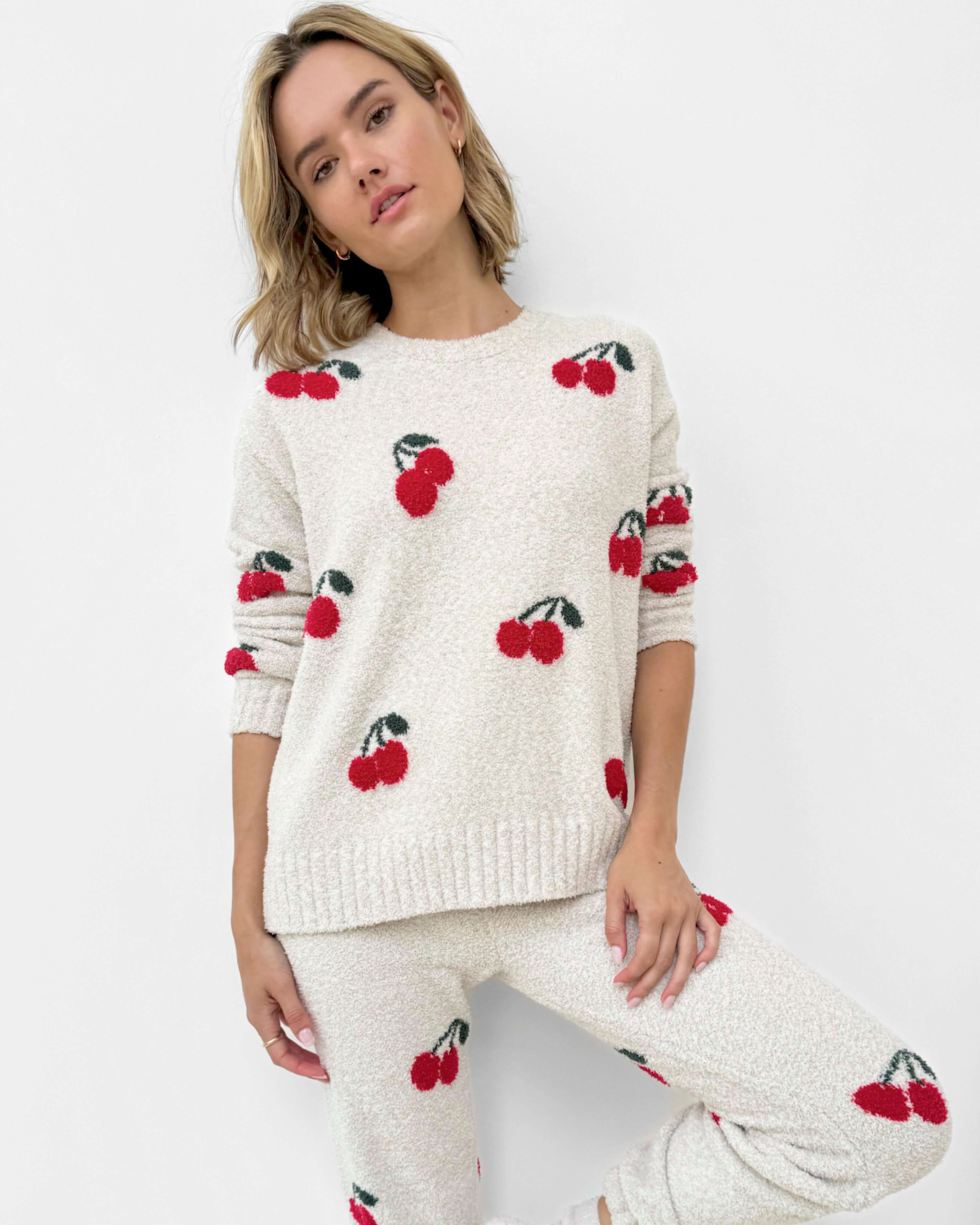 Woman wearing a Cloud-Soft Fuzzy Sweater Pajama Set Splendid with cherry patterns, showcasing cozy loungewear style.