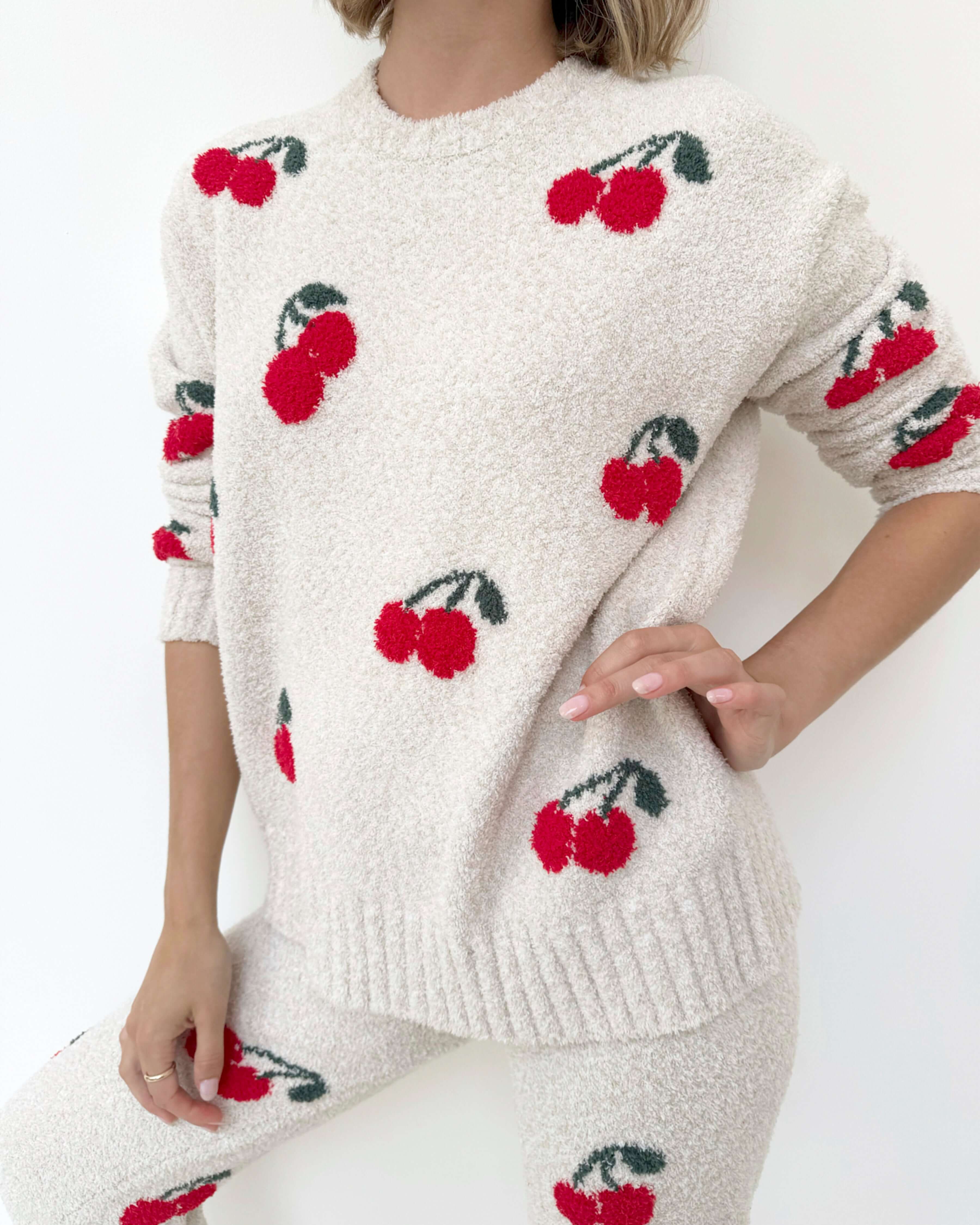 Woman wearing a Cloud-Soft Fuzzy Sweater Pajama Set Splendid with cherry patterns, showcasing cozy loungewear style.