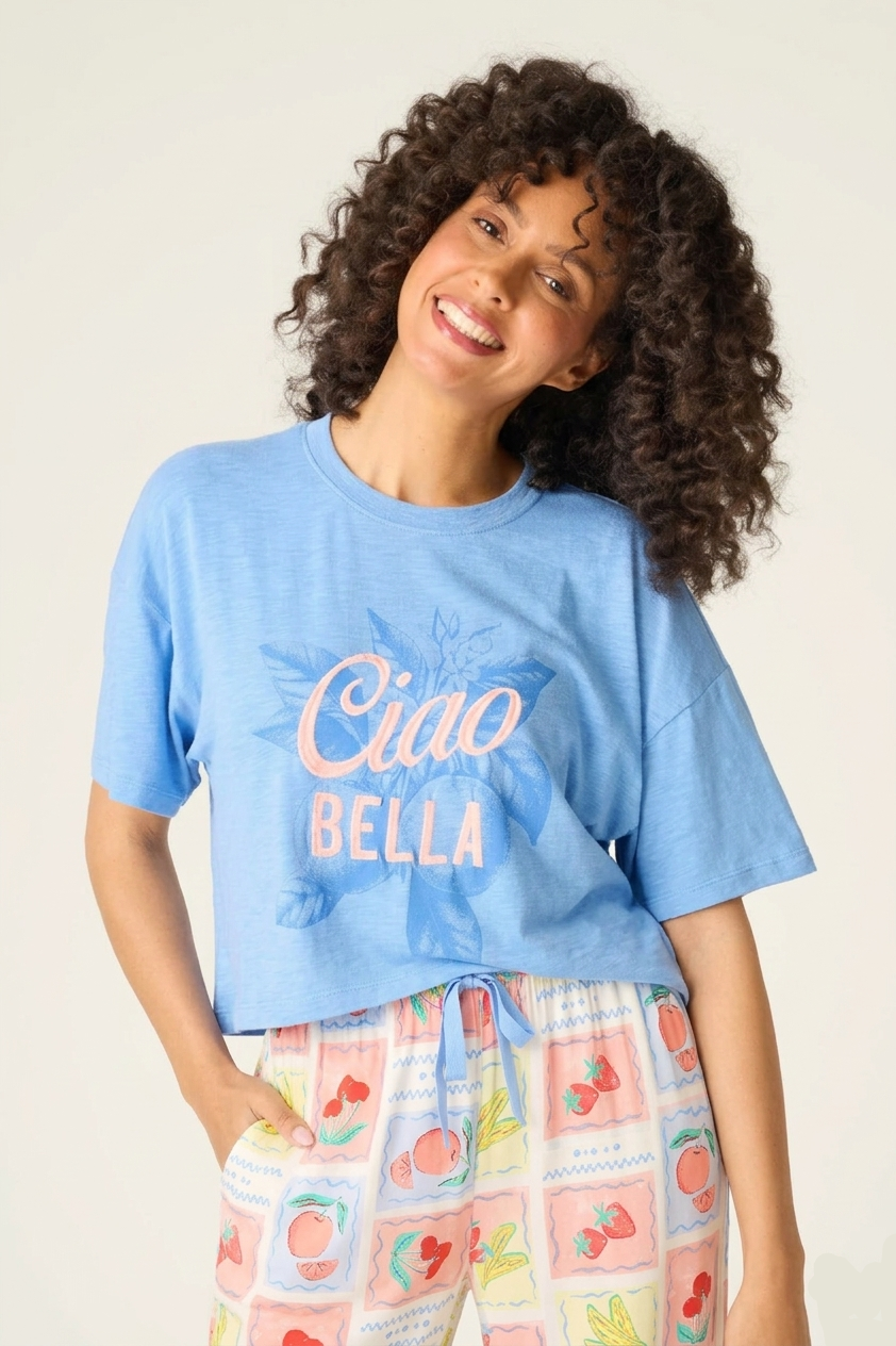 Frutta Fresca Ciao Bella Fruit Print PJ Set by PJ Salvage model wearing blue tee and colorful pajama bottoms.