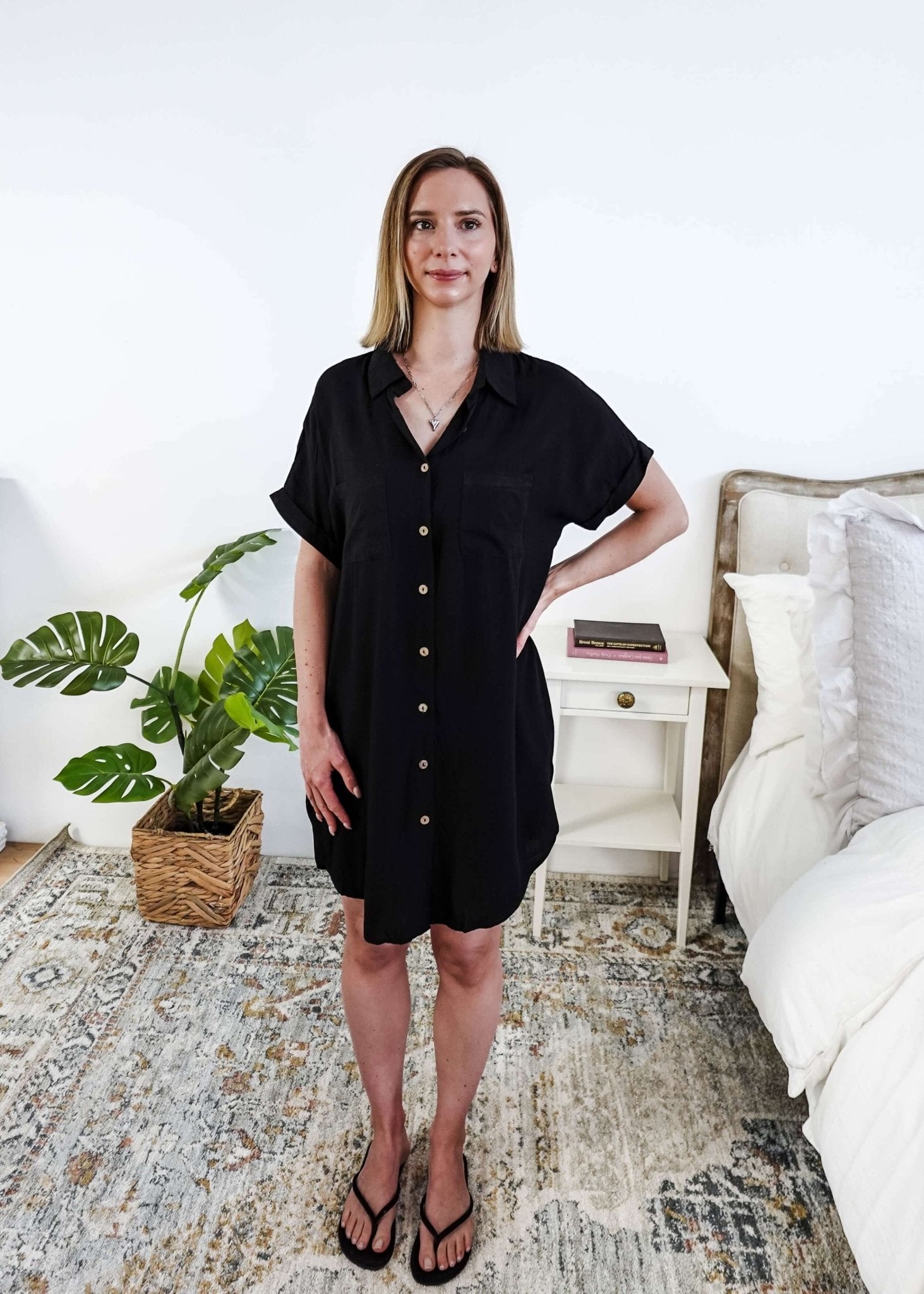 Woman in a room holding a woven bag, wearing a black dress shirt type dress, Scarlett Ellie Collared Button-Up Short Sleeve Dress | Cloud Nine Pajamas