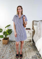 Woman wearing a striped dress in a bedroom setting - Scarlett Ellie Collared Button-Up Short Sleeve Dress | Cloud Nine Pajamas