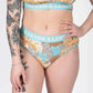 Model showcasing Devon + Lang Bria Full Coverage Bikini Brief with cat print design.