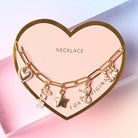 Bella Charm Necklace in 14K Gold featuring heart, star, bow, love script, and pearl charms on a gold chain.